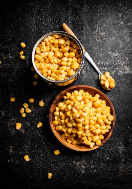 Tahta tabakta konserve mısır. Siyah bir arka planda. Yüksek kalite fotoğraf