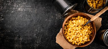 Tahta tabakta konserve mısır. Siyah bir arka planda. Yüksek kalite fotoğraf