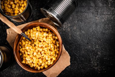 Tahta tabakta konserve mısır. Siyah bir arka planda. Yüksek kalite fotoğraf