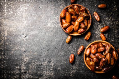 Masada iki tabak hurma var. Siyah bir arka planda. Yüksek kalite fotoğraf