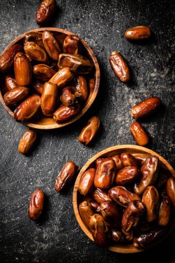 Masada iki tabak hurma var. Siyah bir arka planda. Yüksek kalite fotoğraf