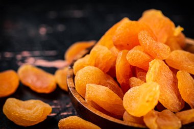 Kurutulmuş kayısı ile dolu ahşap tabak. Karanlık bir arka plana karşı. Yüksek kalite fotoğraf