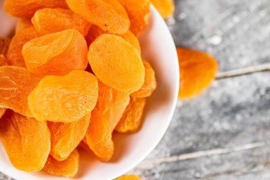 Masadaki bir kasede mis kokulu kayısılar. Gri bir arka planda. Yüksek kalite fotoğraf