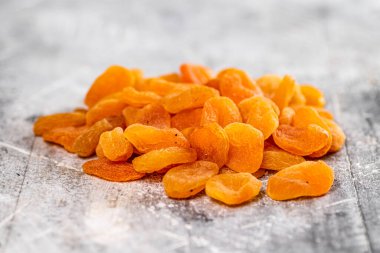 Masada bir yığın lezzetli kurutulmuş kayısı var. Gri bir arka planda. Yüksek kalite fotoğraf