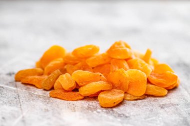 Masada bir yığın lezzetli kurutulmuş kayısı var. Gri bir arka planda. Yüksek kalite fotoğraf