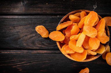 Bir tabak dolusu kurutulmuş kayısı. Ahşap bir arka planda. Yüksek kalite fotoğraf