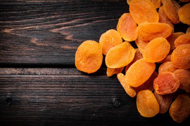 Masada altın gibi lezzetli kurutulmuş kayısılar var. Ahşap bir arka planda. Yüksek kalite fotoğraf