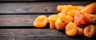 Masada altın gibi lezzetli kurutulmuş kayısılar var. Ahşap bir arka planda. Yüksek kalite fotoğraf