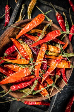 Kesme tahtasında çok renkli kurutulmuş kırmızı biber kabukları. Siyah bir arka planda. Yüksek kalite fotoğraf