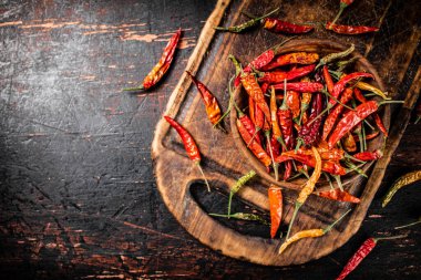 Kesme tahtasındaki tabakta kurutulmuş kırmızı biber. Karanlık bir arka plana karşı. Yüksek kalite fotoğraf