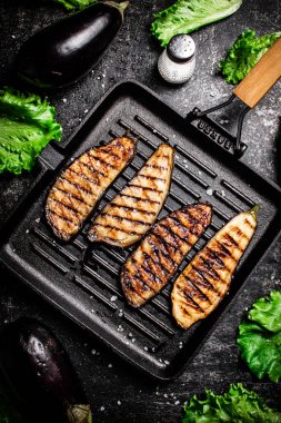 Izgara tavasında patlıcan dilimleri. Siyah bir arka planda. Yüksek kalite fotoğraf