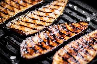 Izgara tavasında patlıcan dilimleri. Siyah bir arka planda. Yüksek kalite fotoğraf