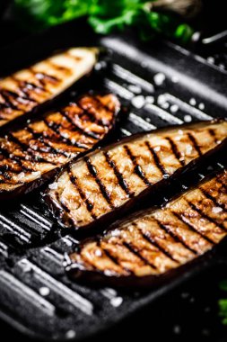 Izgara tavasında patlıcan dilimleri. Siyah bir arka planda. Yüksek kalite fotoğraf