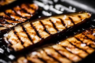 Izgara tavasında patlıcan dilimleri. Siyah bir arka planda. Yüksek kalite fotoğraf