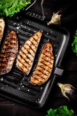 Izgarada kızartılmış patlıcan parçaları. Ahşap bir arka planda. Yüksek kalite fotoğraf