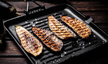 Izgarada kızartılmış patlıcan parçaları. Ahşap bir arka planda. Yüksek kalite fotoğraf