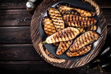 Ahşap tepside bir tabakta ızgara patlıcan. Ahşap bir arka planda. Yüksek kalite fotoğraf