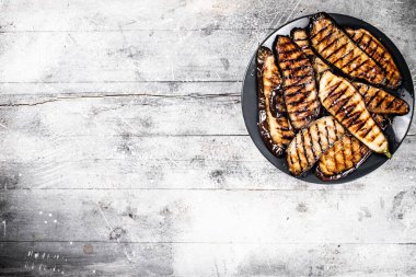 Tabakta ızgara patlıcan parçaları. Gri bir arka planda. Yüksek kalite fotoğraf