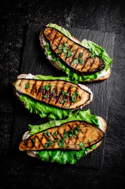 Kayalıklarda ızgara patlıcanlı sandviç. Siyah bir arka planda. Yüksek kalite fotoğraf