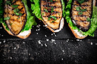 Kayalıklarda ızgara patlıcanlı sandviç. Siyah bir arka planda. Yüksek kalite fotoğraf