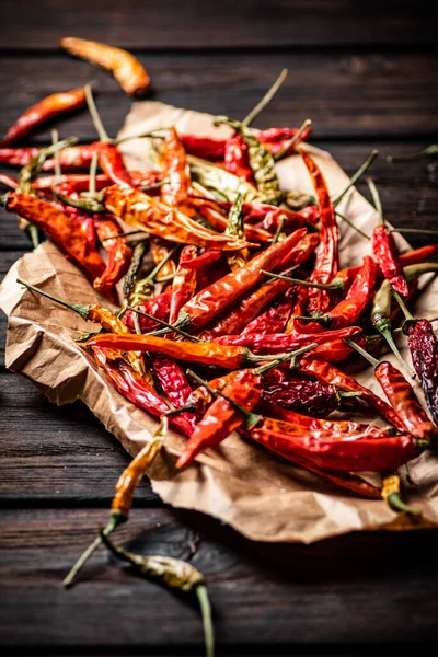 stock image Dried chili peppers on paper. On a wooden background. High quality photo