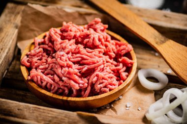 Tahta tepside kıyma ve soğan halkaları. Karanlık bir arka plana karşı. Yüksek kalite fotoğraf