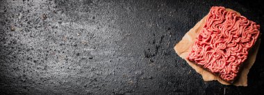 Masadaki kağıt üzerinde çiğ et. Siyah bir arka planda. Yüksek kalite fotoğraf