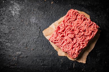 Masadaki kağıt üzerinde çiğ et. Siyah bir arka planda. Yüksek kalite fotoğraf