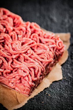 Masadaki kağıt üzerinde çiğ et. Siyah bir arka planda. Yüksek kalite fotoğraf