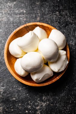 Masadaki ahşap tabakta Mozzarella peyniri. Siyah bir arka planda. Yüksek kalite fotoğraf