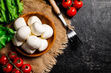 Peçetede domates ve marullu bir tabakta Mozzareella. Siyah bir arka planda. Yüksek kalite fotoğraf