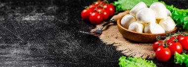 Peçetede domates ve marullu bir tabakta Mozzareella. Siyah bir arka planda. Yüksek kalite fotoğraf