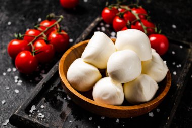 Çeri domatesli dilimleme tahtasındaki Mozzarella peyniri. Siyah bir arka planda. Yüksek kalite fotoğraf