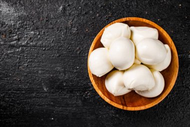 Masadaki ahşap tabakta Mozzarella peyniri. Siyah bir arka planda. Yüksek kalite fotoğraf