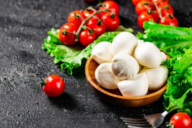 Kiraz domatesli ve marullu Mozzarella peyniri. Siyah bir arka planda. Yüksek kalite fotoğraf