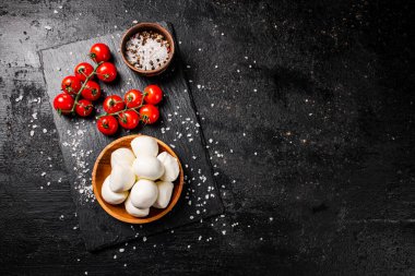 İçinde domates ve baharatlar olan bir tabakta Mozzarella peyniri. Siyah bir arka planda. Yüksek kalite fotoğraf