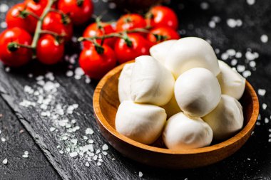 İçinde domates ve baharatlar olan bir tabakta Mozzarella peyniri. Siyah bir arka planda. Yüksek kalite fotoğraf