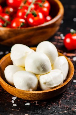 Masada mozarellalı ahşap bir tabak. Karanlık bir arka plana karşı. Yüksek kalite fotoğraf