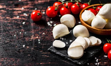 Domatesli bir taş tahtada dilimlenmiş mozzarella. Karanlık bir arka plana karşı. Yüksek kalite fotoğraf
