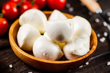 Masada domates ve baharatlarla dolu bir tabakta Mozzarella peyniri. Ahşap bir arka planda. Yüksek kalite fotoğraf