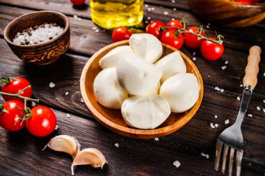 Masada domates ve baharatlarla dolu bir tabakta Mozzarella peyniri. Ahşap bir arka planda. Yüksek kalite fotoğraf