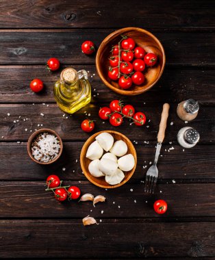 Masada domates ve baharatlarla dolu bir tabakta Mozzarella peyniri. Ahşap bir arka planda. Yüksek kalite fotoğraf