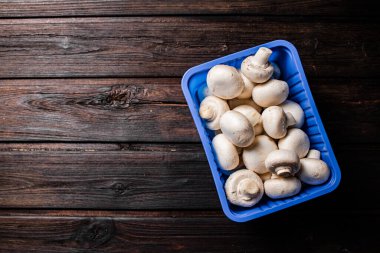 Masadaki plastik kutuda mantarlar. Ahşap bir arka planda. Yüksek kalite fotoğraf