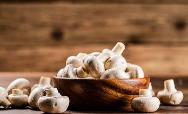 Taze mantar dolu ahşap bir tabak. Ahşap bir arka planda. Yüksek kalite fotoğraf