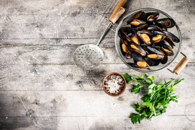 Masadaki süzgeçte kaynamış midye. Gri bir arka planda. Yüksek kalite fotoğraf