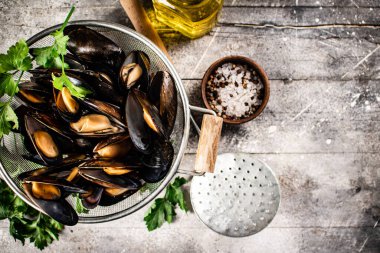 Masadaki süzgeçte kaynamış midye. Gri bir arka planda. Yüksek kalite fotoğraf