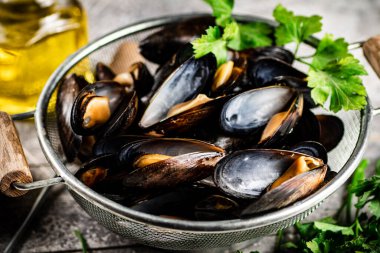 Masadaki süzgeçte kaynamış midye. Gri bir arka planda. Yüksek kalite fotoğraf