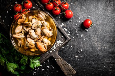 Kiraz domatesli bir kesme tahtasındaki kasede midye turşusu. Siyah bir arka planda. Yüksek kalite fotoğraf