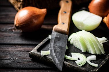 Kesme tahtasındaki soğan parçaları. Ahşap bir arka planda. Yüksek kalite fotoğraf