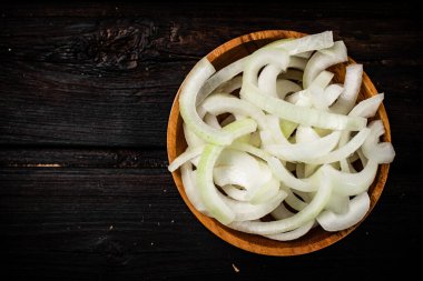İçinde soğan parçaları olan ahşap bir tabak. Ahşap bir arka planda. Yüksek kalite fotoğraf
